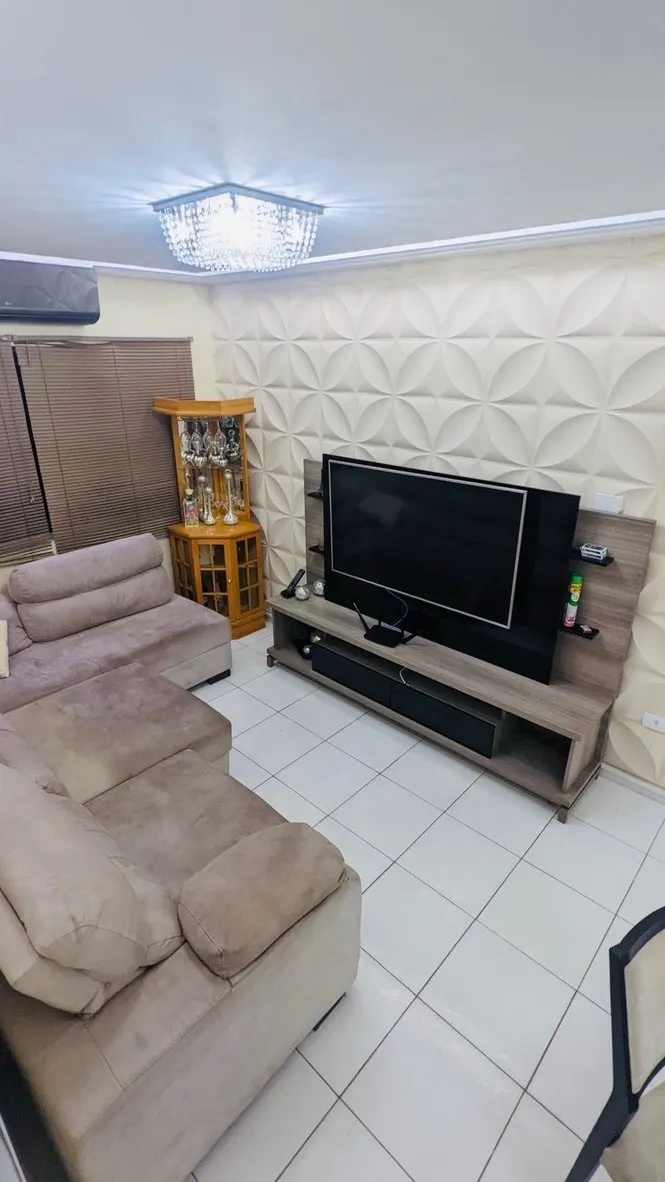 Sala com sofá, rack com TV e cristaleira