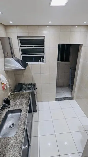 Cozinha com bancada de granito e passagem para a área de serviço