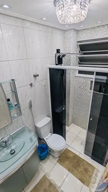 Banheiro com box de vidro e lustre