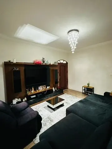 Sala com estante de TV, sofá e iluminação zenital