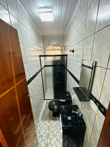 Lavabo com cuba preta e porta de madeira