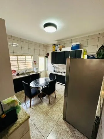 Cozinha com mesa de jantar redonda e armários pretos