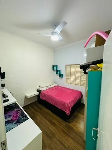 Quarto com cama de solteiro, ventilador de teto e piso de madeira