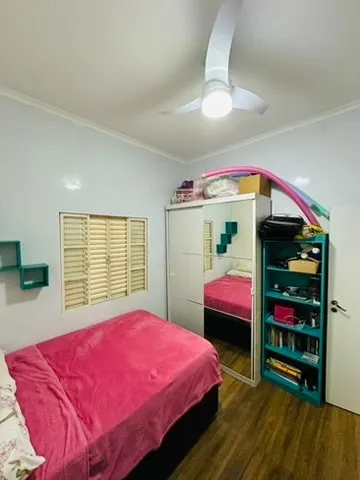 Quarto com cama, armário espelhado e estante