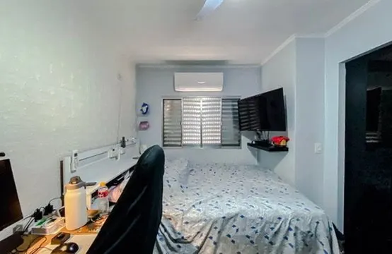 Quarto com cama, escrivaninha e ar-condicionado