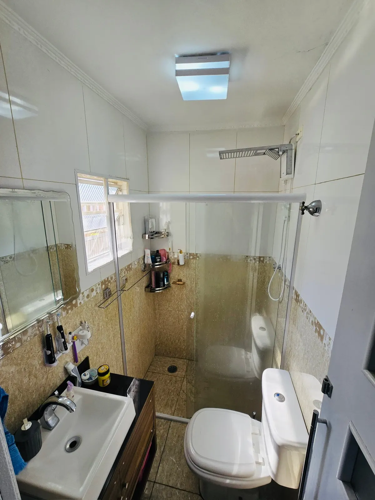 Banheiro com box de vidro e gabinete