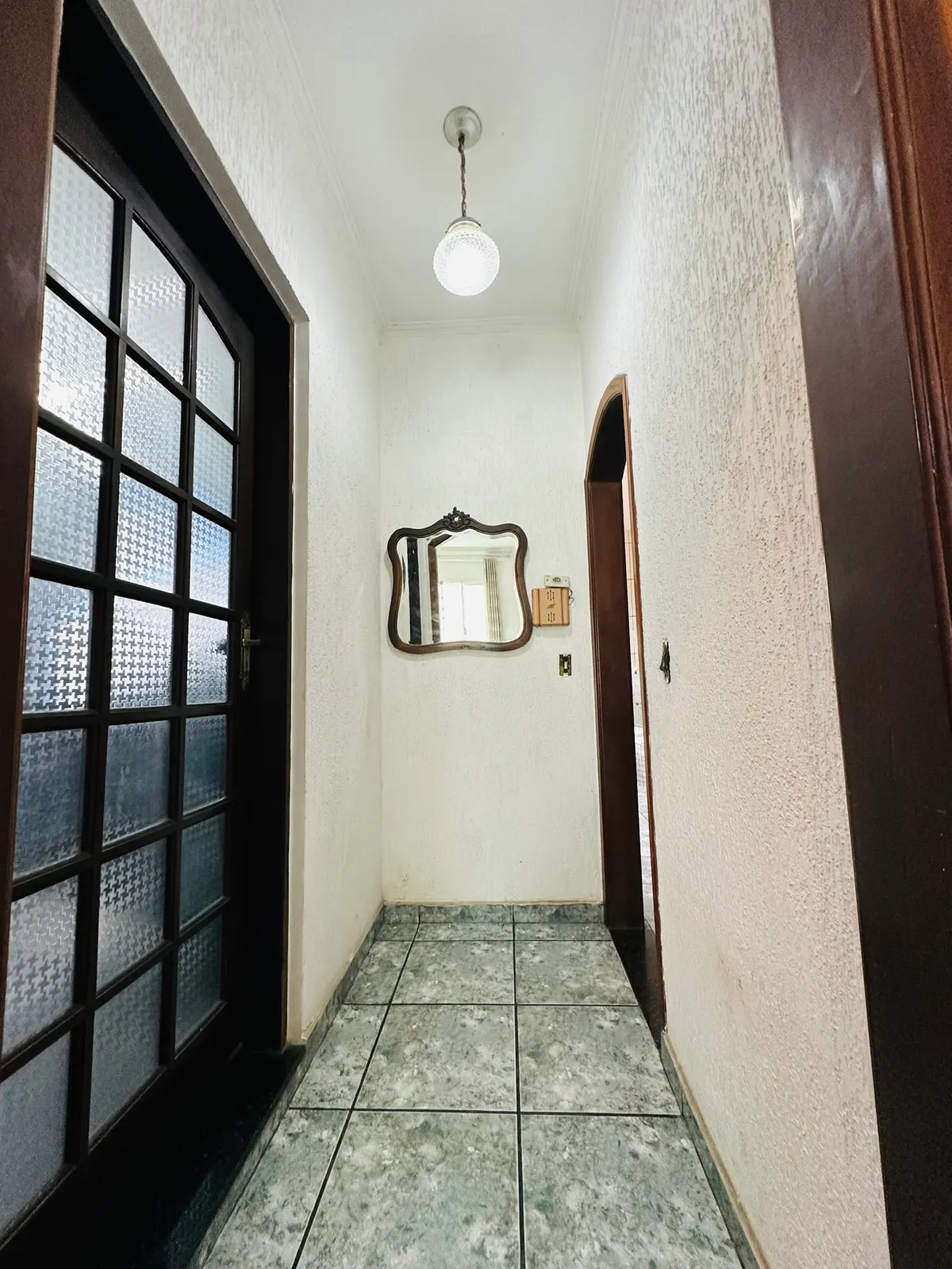 Hall com porta de vidro e espelho
