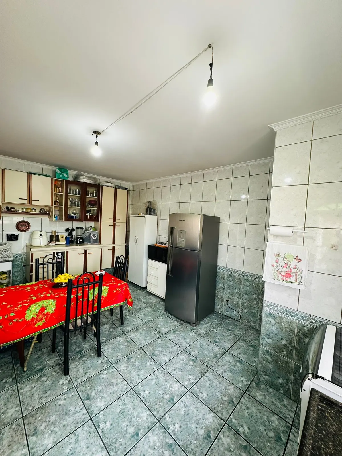Cozinha com mesa, geladeira inox e armários