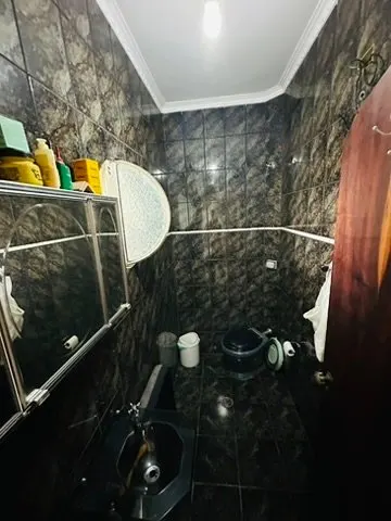 Banheiro com revestimento escuro